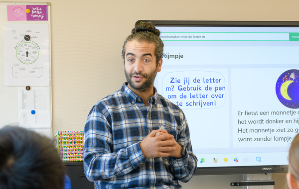 Leraard die voor de klas staat en iets uitlegt.