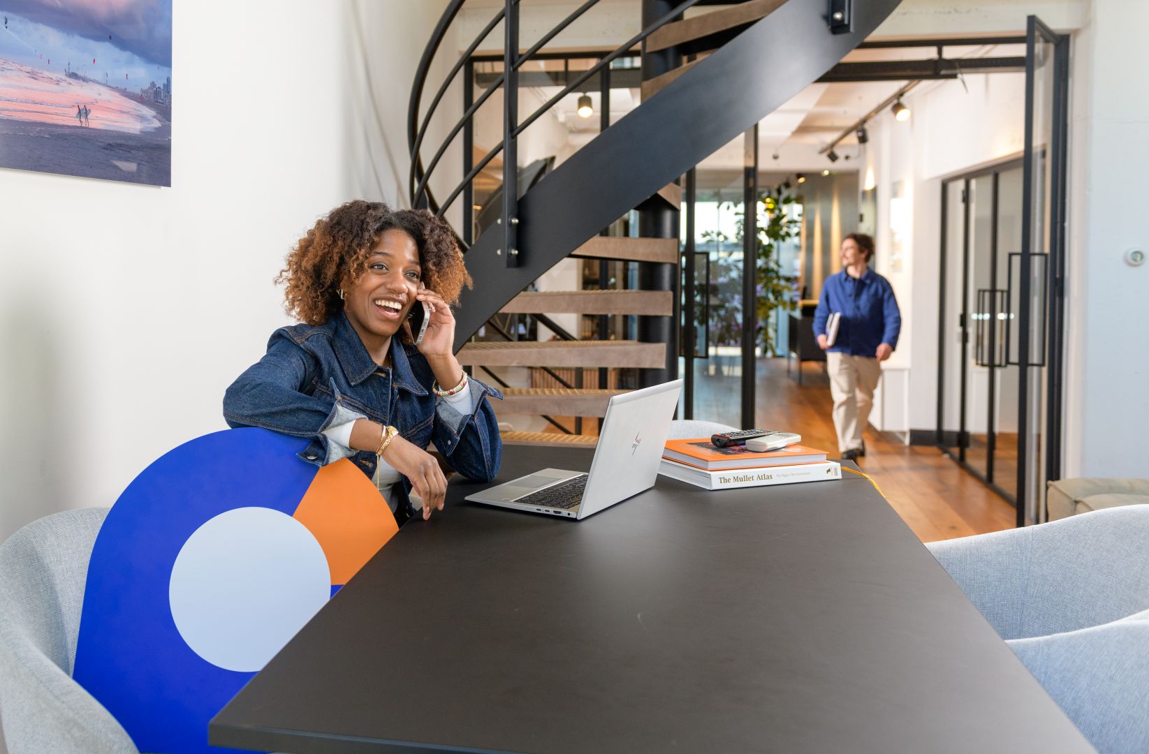 HR adviseur die aan een tafel aan het bellen is steunend op met de landelijke pointer onder haar arm.